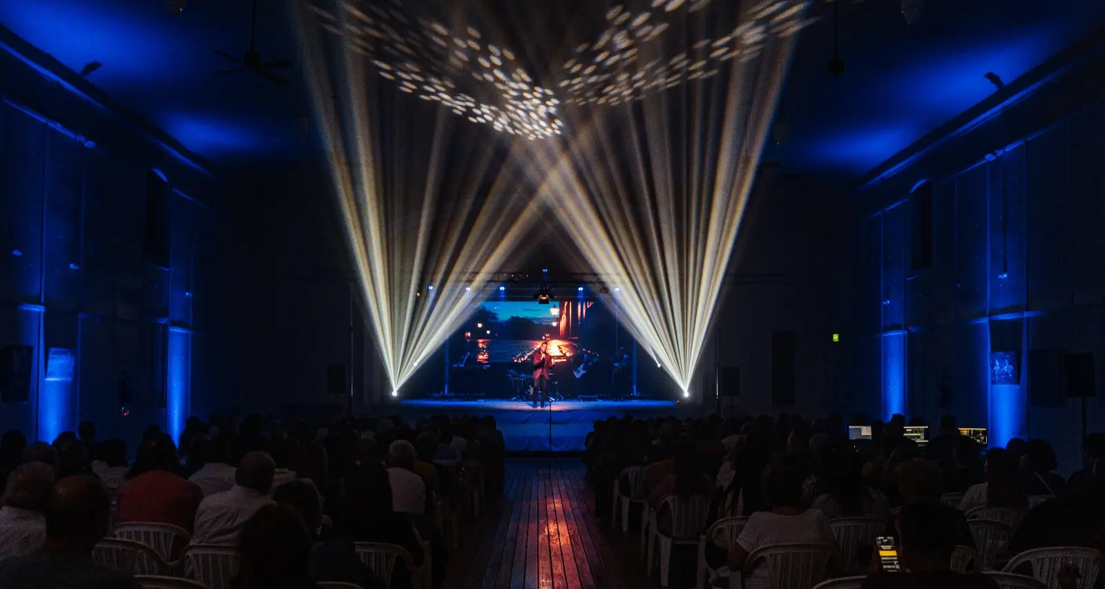 Escenario iluminado frente al público durante un evento