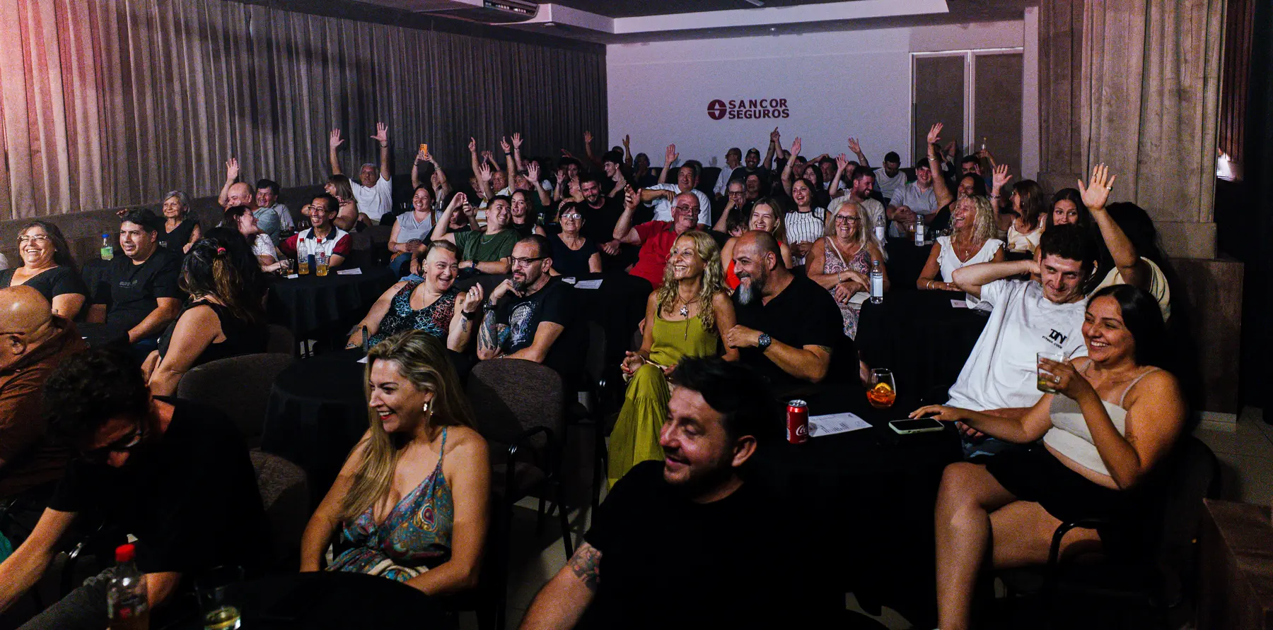 Público sonriente participando de una experiencia musical